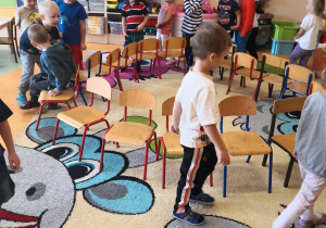 dzieci chodzą w koło krzesełek